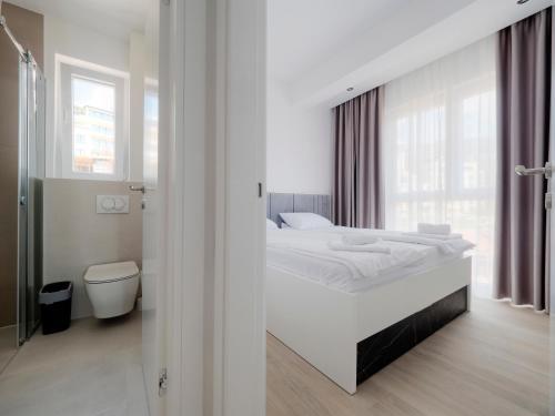 a white bedroom with a bed and a toilet at Horizon-Two Bedroom Apartment Partial Sea View Charlene in Becici