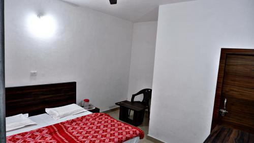 a bedroom with a bed with a red blanket at Saatvik Homestay in Katra