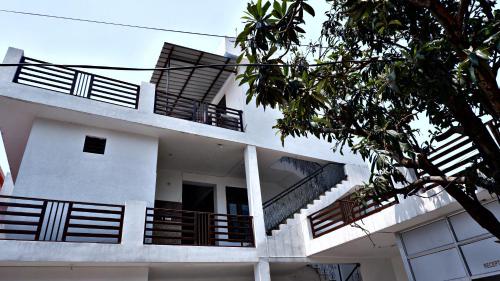 a white building with balconies and stairs on it at Saatvik Homestay in Katra