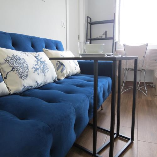 a blue couch with a table in a living room at Piso Virgen del mar in Laxe