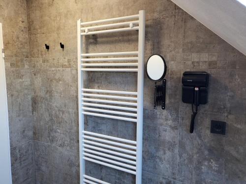 a white ladder in a bathroom with a mirror at FeWo-Brak in Norden