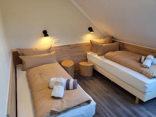 a room with two beds and two tables at FeWo-Brak in Norden