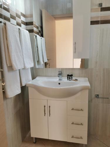 a bathroom with a white sink and a mirror at Venetiko rooms in Chios