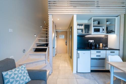 a small kitchen and staircase in a small apartment at Kyriad Résidence Cabriès - Plan de Campagne in Cabriès