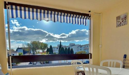 a window with a view of a city at Agréable Studio Cabine - piscine - parking - proche Plage RICHELIEU in Cap d'Agde