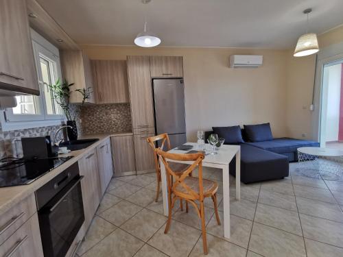 een keuken en een woonkamer met een tafel en een bank bij Marine Apartments Venetiko in Chios