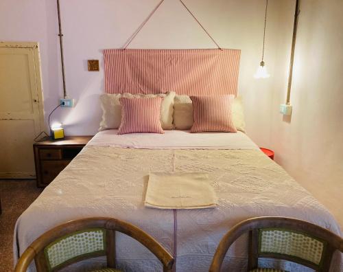 a bedroom with a large bed with two chairs at Il balconcino di Riamori in Amelia