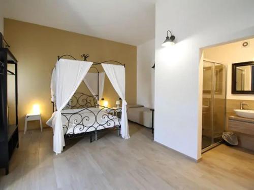 1 dormitorio con cama con dosel y lavamanos en Hotel Calabernardo Noto Marina en Calabernardo