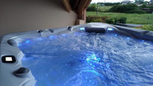 d'un bain à remous avec de l'eau bleue dans la cour. dans l'établissement Villa Jacuzzi au pied de la Baie du Mont St Michel, à Genêts