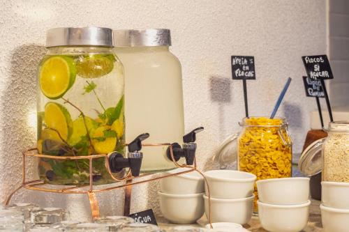 a jar of lemonade sitting on a counter with cups at Novotel Salvador Rio Vermelho in Salvador