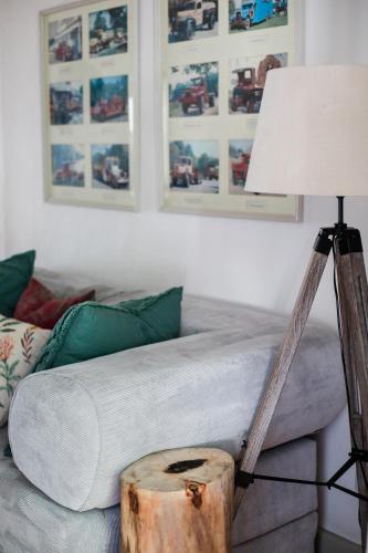 a living room with a couch with a lamp and a table at River Bend Guesthouses in Graaff-Reinet