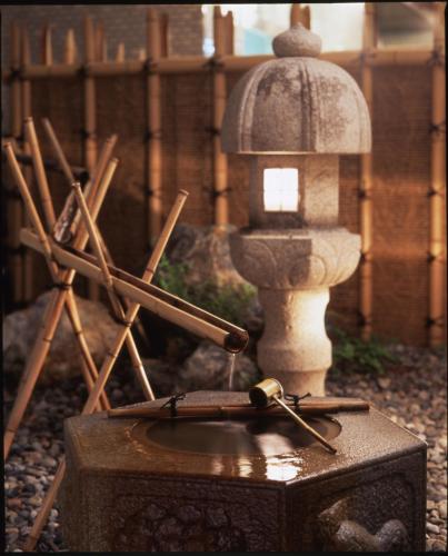 a wooden box with a fountain and wooden sticks at Entaijiso in Kurobe