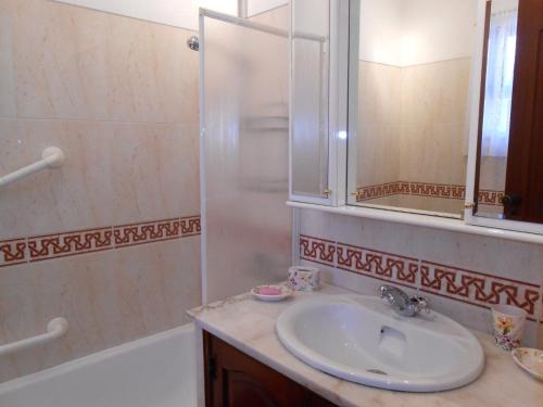 a bathroom with a sink and a shower and a mirror at Villa Cabanas in Tavira