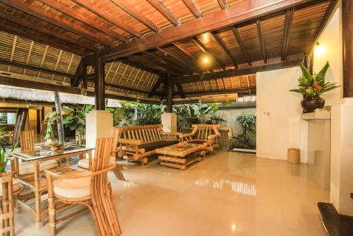 a living room with wooden chairs and a table at Radiant Jepun Villa in Legian
