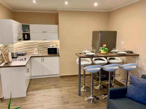 a kitchen with a table and some bar stools at Milano Vendégház in Bakonybél