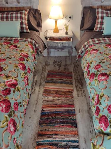2 camas en una habitación con alfombra en el suelo en El Racó de la Civaderia, casa en Montblanc en Montblanc
