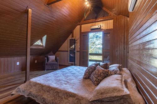 ein Schlafzimmer mit einem Bett in einem Zimmer mit Holzwänden in der Unterkunft @Chalet.Home in Nova Veneza