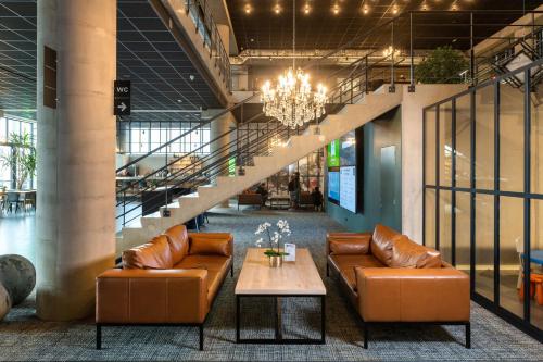 a lobby with couches and a table and stairs at ibis Styles Namur in Namur