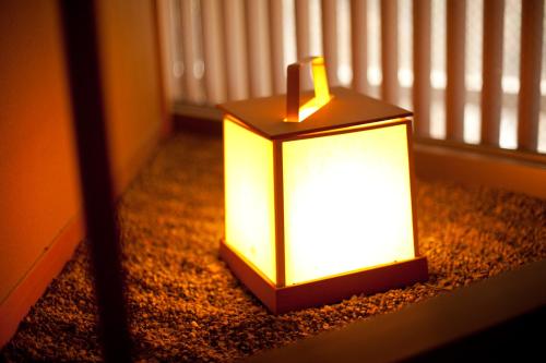 a lit lantern sitting on the floor in a room at Entaijiso in Kurobe