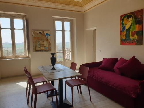 sala de estar con sofá rojo y mesa en OLIVOLA APARTMENTS, en Frassinello Olivola
