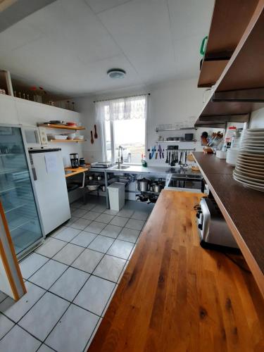a large kitchen with white appliances and wooden floors at Rauðsdalur in Brjánslækur