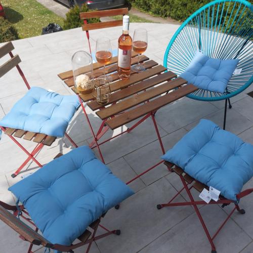 a picnic table with two chairs and a bottle of wine at Ivančica in Aljmaš