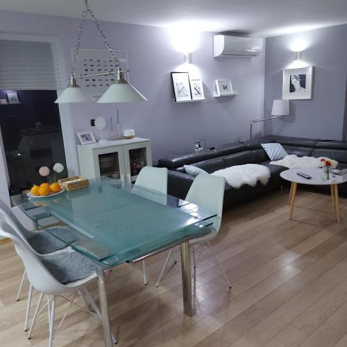 a living room with a glass table and a couch at Ivančica in Aljmaš