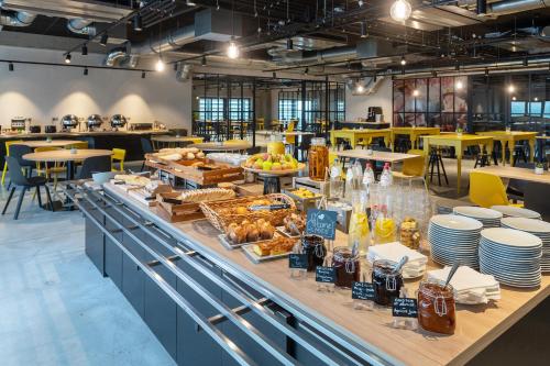 a breakfast buffet in a restaurant with tables and chairs at ibis Styles Namur in Namur