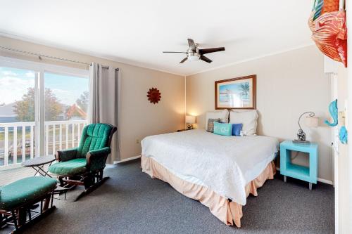 een slaapkamer met een bed en 2 stoelen en een balkon bij Bayside Beauty in Ocean City