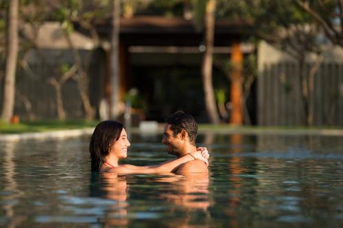 a man and a woman standing in a swimming pool at The Samaya Seminyak Bali in Seminyak