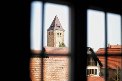 - une vue sur une tour d'horloge depuis une fenêtre dans l'établissement Maison 1686, à Niedernai