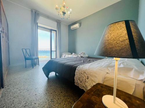 サンタ・マリア・ディ・カステッラバーテにあるCasa Vacanze Porto delle Gatteのベッドルーム1室(ベッド1台、ランプ付きテーブル付)