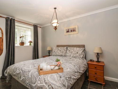 a bedroom with a bed with a tray on it at The Retreat in Liskeard