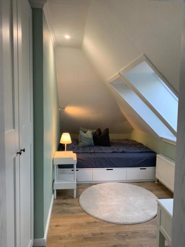 a attic bedroom with a bed and a rug at Sonniges Stadt-Apartment in ruhiger Parklage in Bad Segeberg