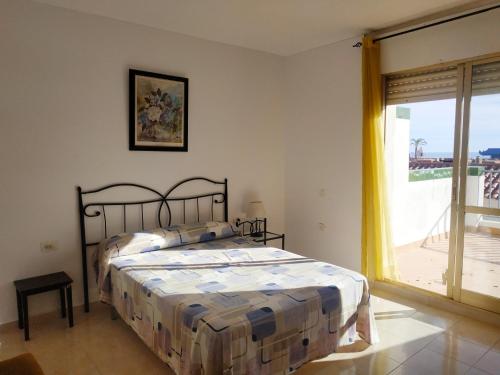 a bedroom with a bed and a large window at Duplex vista mar Peñiscola Playa Orangecosta in Peniscola