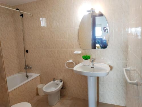 a bathroom with a sink and a toilet and a mirror at Duplex vista mar Peñiscola Playa Orangecosta in Peniscola