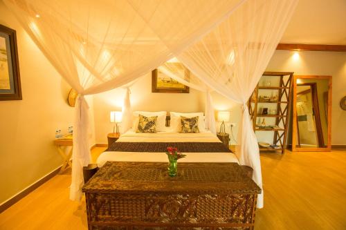 sypialnia z łóżkiem z białym baldachimem w obiekcie Amani Safari Lodge and Restaurant w mieście Arusza