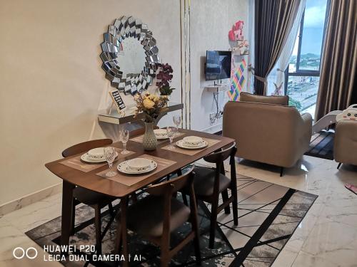 einen Esstisch im Wohnzimmer mit Spiegel in der Unterkunft Prestige Troika Kota Bharu in Kota Bharu