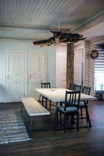 a table and chairs in a room with a tree at Spithami Puhkemajad seltskonna puhkemaja in Põõsaspea