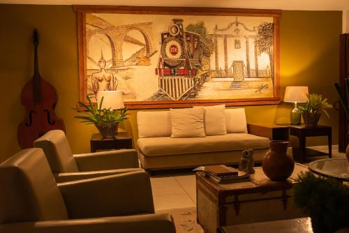 a living room with a couch and a guitar at Hotel Fazenda Vilarejo All Inclusive in Conservatória