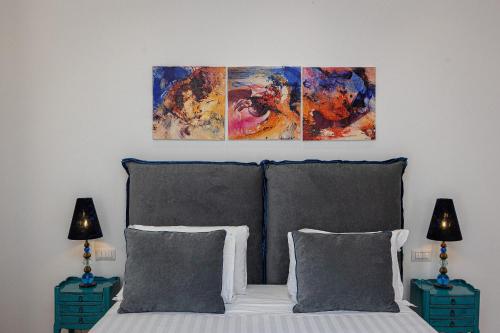 a bedroom with a bed with three paintings above it at Suite della Pigna in Rome