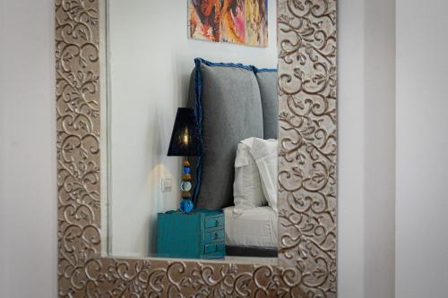 a mirror in a room with a chair and a lamp at Suite della Pigna in Rome