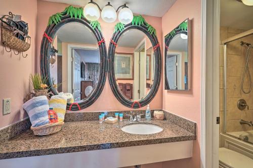 a bathroom with a sink and two mirrors at Breezy Kaunakakai Retreat with Community Pool! in Kaunakakai