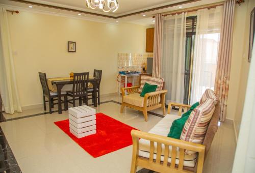 a living room with a table and chairs at Keisha Luxury Furnished Apartment Bukoto in Kampala