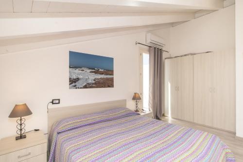 Habitación blanca con cama y ventana en Ulivi 17 en Isola Rossa