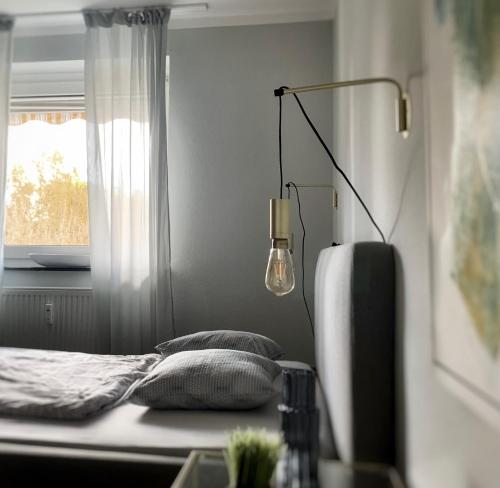 ein Schlafzimmer mit einem Bett, einer Lampe und einem Fenster in der Unterkunft Angie´s Home in Saarlouis