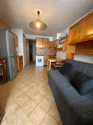 a living room with a couch and a kitchen at Laye station -les Arolles b - 4 personnes in Laye