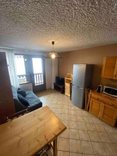 a living room with a couch and a refrigerator at Laye station -les Arolles b - 4 personnes in Laye