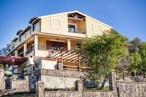 a large house with a stone fence in front of it at VILLA KONSTANTINA Sidari in (( Sgoúrna ))