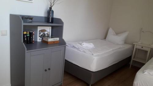 a small bedroom with a bed and a night stand at Ferienwohnung Born am Darßwald EG in Born